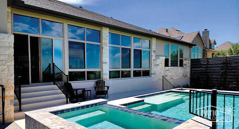 Exterior of a tan patio enclosure overlooking a two-level pool.
