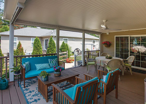 A patio cover elegantly adorned with blue outdoor living furniture and a dining area
